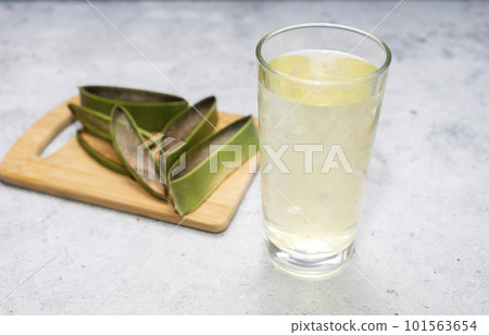 Slices of Aloe Vera Plant And Glass Of Aloe Vera Juice, Drink On Table. Horizontal plane. Healthy Beverage, Refreshment, Antioxidant. Top view, Closeup Slices of Aloe Vera Plant And Glass Of Aloe Vera Juice, Drink On Table. Horizontal plane. Healthy Beverage, Refreshment, Antioxidant. Top view, Closeup 101563654