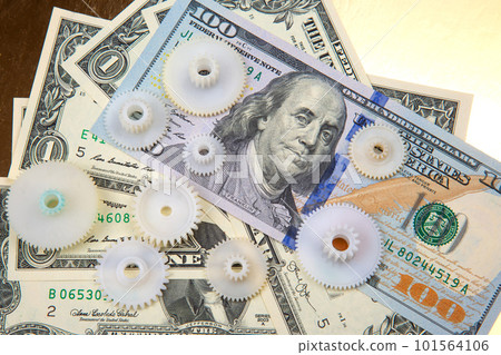 Plastic gears on the background of dollars.  101564106
