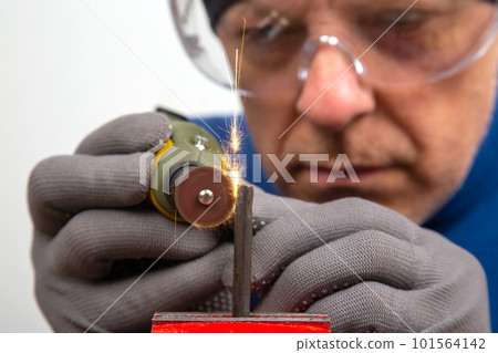 Male locksmith Worker processes metal with engraving drill. Male locksmith Worker processes metal with engraving drill. 101564142