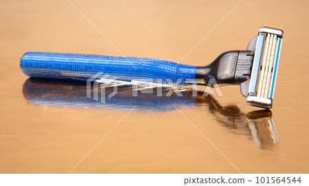 razor cassette on golden background. manual face shaving machine. stubble blade. depilation 101564544