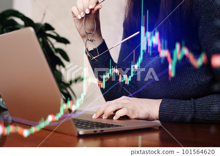 Businesswoman working with laptop on wooden desk, stock market chart. 101564620