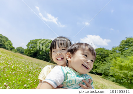 My older sister and brother playing in a fresh green park 101565811