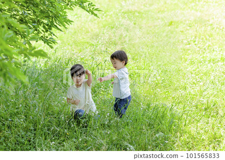My older sister and brother playing in a fresh green park 101565833