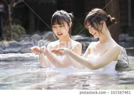 Two young women taking a leisurely open-air bath 101567461