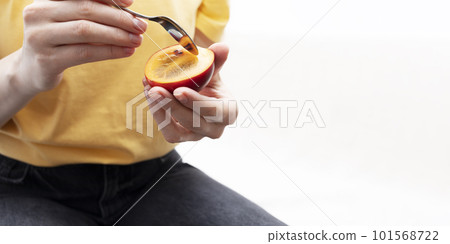 Someone, Woman Eating Fresh Tamarillo, Fresh Exotic Fruit With Spoon. Egg-shaped Edible Fruit Known As Tree Tomato, Plant Family Solanaceae, Solanum Betaceum. Copy space for text. Horizontal Plane 101568722