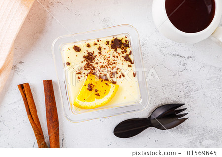 Tiramisu dessert in a plastic box with a fork on a concrete background. 101569645