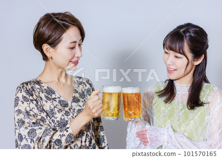 兩個女人用啤酒敬酒 兩個女人用啤酒敬酒 101570165