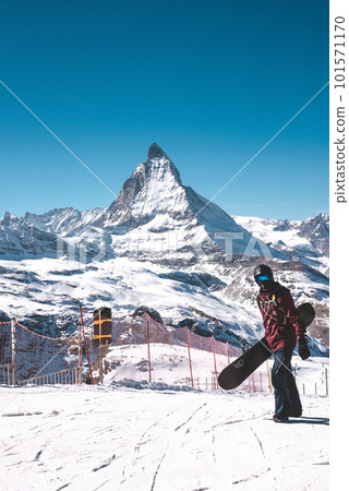 Young snowboarder spending winter holidays in Zermatt, near the famous Matterhorn peak. Male posing in Swiss Alps for the snowboarding season. 101571170