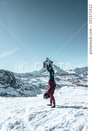 Young snowboarder spending winter holidays in Zermatt, near the famous Matterhorn peak. Male posing in Swiss Alps for the snowboarding season. 101571412