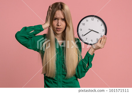 Confused woman with anxiety checking time on clock, running late to work, being in delay, deadline Confused woman with anxiety checking time on clock, running late to work, being in delay, deadline 101571511