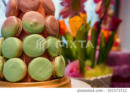 Wedding decoration with pastel colored cupcakes, meringues, muffins and macarons. Elegant and luxurious event arrangement with colorful macaroons. Wedding dessert with macaroons Wedding decoration with pastel colored cupcakes, meringues, muffins and macarons. Elegant and luxurious event arrangement with colorful macaroons. Wedding dessert with macaroons 101571512