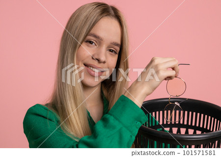 Woman taking off, throwing out glasses into bin after medical vision laser treatment therapy surgery 101571581