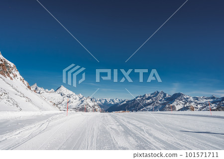 Ski slope and snow covered winter mountains. Matterhorn is a mountain in the Pennine Alps on the border between Switzerland and Italy. Peak of the Matterhorn Glacier Paradise. Ski slope and snow covered winter mountains. Matterhorn is a mountain in the Pennine Alps on the border between Switzerland and Italy. Peak of the Matterhorn Glacier Paradise. 101571711
