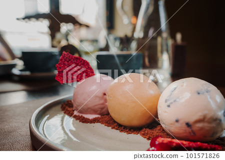 Yummy delicious colorful ice cream on a plate next to the coffee. Yummy delicious colorful ice cream on a plate next to the coffee. 101571826