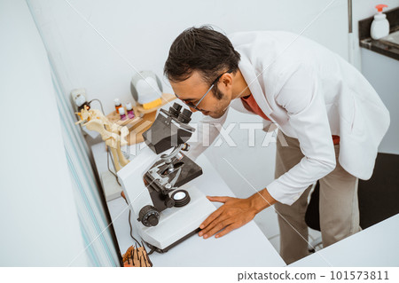 a handsome vet with eye glasses operate the stethoscope a handsome vet with eye glasses operate the stethoscope 101573811