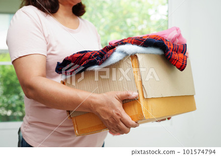 Clothes donations in cardboard box for volunteer. 101574794