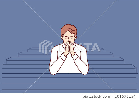 Christian man sits and prays in catholic church, turning to god to confess or ask for help 101576154