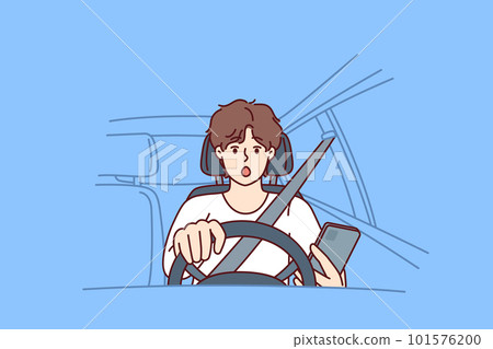 Man driver with phone sits behind wheel of car and gets scared sees obstacle on road or sharp turn 101576200