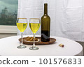 white wine bottle and glass on white table white wine bottle and glass on white table 101576833