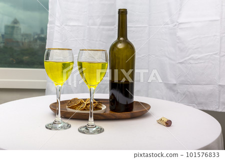 white wine bottle and glass on white table white wine bottle and glass on white table 101576833
