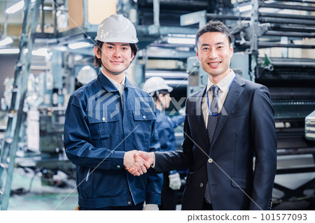 Businessmen shaking hands in a factory 101577093