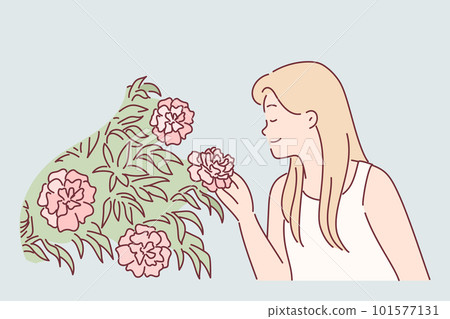Woman enjoys scent of rose flowers by inhaling scent while walking in park or greenhouse 101577131