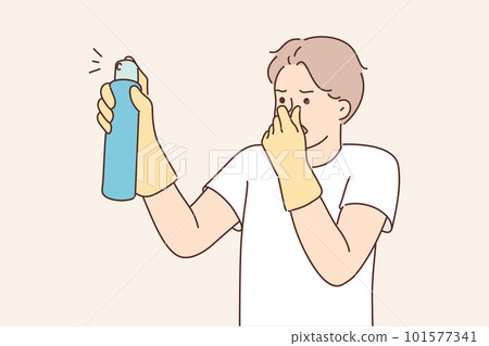 Dissatisfied man with spray to remove unpleasant odors covers nose with hand spraying freshener Dissatisfied man with spray to remove unpleasant odors covers nose with hand spraying freshener 101577341