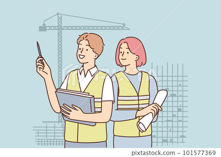 Man and woman in construction uniforms inspect construction site with unfinished high-rise buildings Man and woman in construction uniforms inspect construction site with unfinished high-rise buildings 101577369