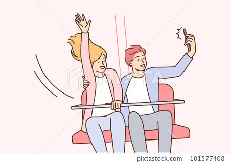 Happy couple ride attractions in park and take selfie for family photo album or love story video 101577408