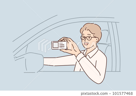 Man driving car demonstrates driver license giving right to work in taxi company 101577468