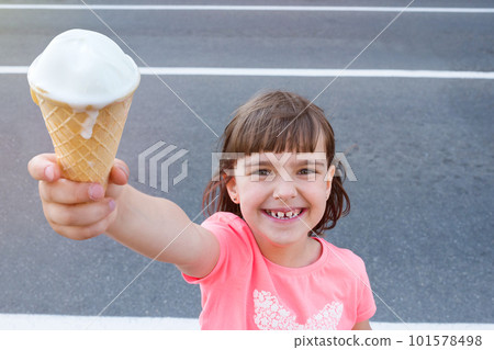 Outdoor portrait of a happy girl with ice cream in hands closeup 101578498