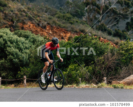 Young male cyclist on a road bike. Professional cyclist exercising outdoors. Young male cyclist on a road bike. Professional cyclist exercising outdoors. 101578499