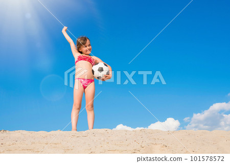 Happy little girl has fun playing on the beach on a sunny summer day. Healthy lifestyle. Happy little girl has fun playing on the beach on a sunny summer day. Healthy lifestyle. 101578572