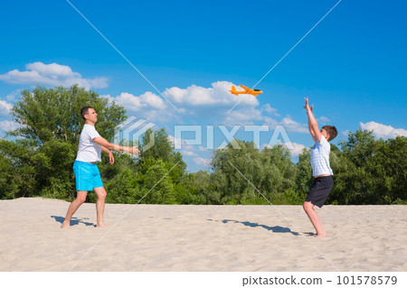Boy and father are playing on the beach on a sunny warm summer day. Concept about sports and active games in summer. Healthy lifestyle. 101578579
