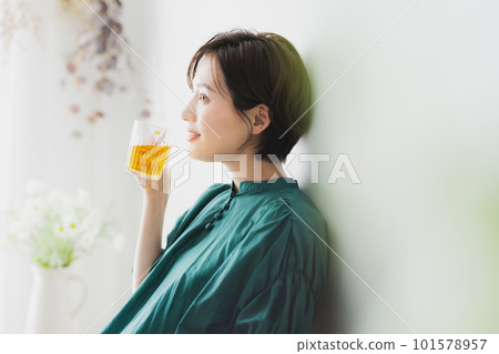 A young woman drinking tea in her room 101578957