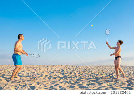 Boy with his father play badminton on the summer beach. Healthy lifestyle, recreation, sports. 101580461