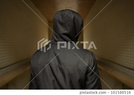 A man in a hood on the street. Social problems, drug addiction and criminal activity. A man in a hood on the street. Social problems, drug addiction and criminal activity. 101580516