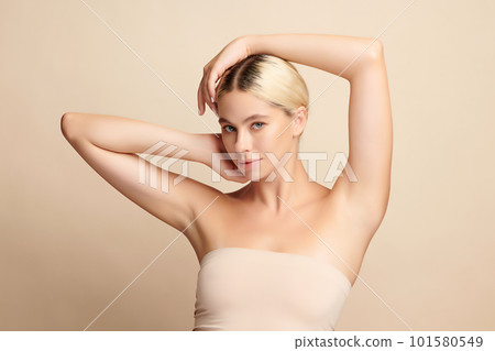 Beautiful Young woman lifting hands up to show off clean and hygienic armpits or underarms on beige background, Smooth armpit cleanliness and protection concept. Beautiful Young woman lifting hands up to show off clean and hygienic armpits or underarms on beige background, Smooth armpit cleanliness and protection concept. 101580549
