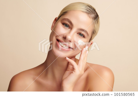 Beautiful young woman applying face cream on beige background, Face care, Facial treatment, Cosmetology, beauty and spa, Asian women portrait. 101580565