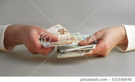 Women's hands hold, count money in euros and dollars isolated on a gray background Women's hands hold, count money in euros and dollars isolated on a gray background 101580640