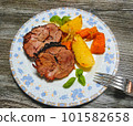 Braised roll roast with potato wedges and carrots on plate, top view 101582658