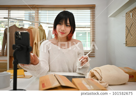 Young asian female small business owner in casual clothes and checking customer address or orders in an online store Young asian female small business owner in casual clothes and checking customer address or orders in an online store 101582675