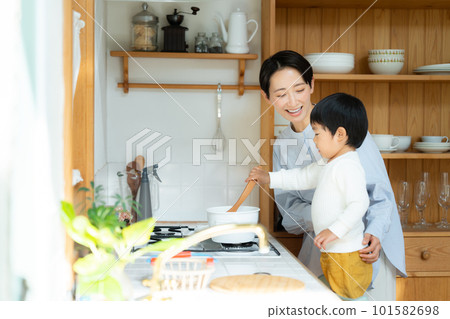 A 3-year-old boy playing with his mother in the kitchen 101582698