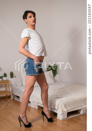 Gay posing in bedroom in shorts and high heels. Gay posing in bedroom in shorts and high heels. 101583047