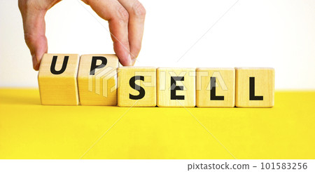 Sell or upsell symbol. Concept word Sell Upsell on wooden cubes. Businessman hand. Beautiful yellow table white background. Business Sell or Upsell concept. Copy space. 101583256