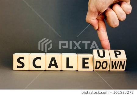 Scale up or down symbol. Concept words Scale up Scale down wooden cubes. Businessman hand. Beautiful grey table grey background. Business scale up or down concept. Copy space. 101583272