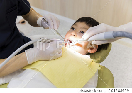 child receiving dental treatment child receiving dental treatment 101588659