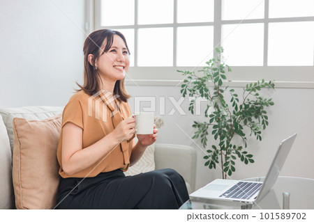 Remote work, telework, telecommuting Asian woman drinking coffee and taking a break 101589702