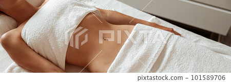 Slim young woman lying on massage table in spa salon Slim young woman lying on massage table in spa salon 101589706