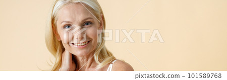 Portrait of charming mature woman with blonde hair in white underwear smiling at camera, posing isolated over beige background Portrait of charming mature woman with blonde hair in white underwear smiling at camera, posing isolated over beige background 101589768